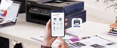 Een Brother-applicatie voor mobiel printen op een telefoon gezien met op de achtergrond een zwarte Brother-printer op een bureau.
